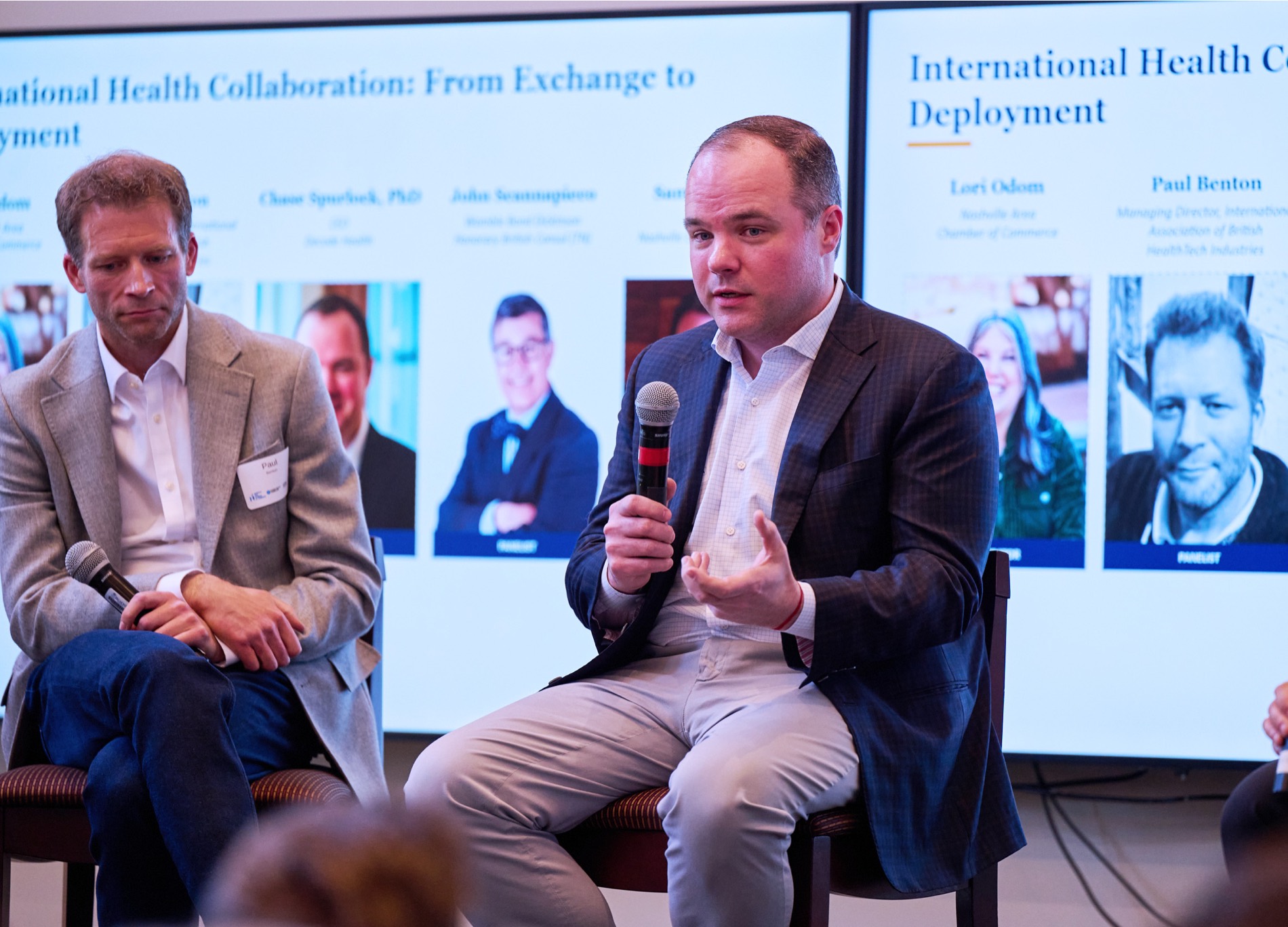 Lori Odom of the Nashville Area Chamber of Commerce speaks at a lectern beside Sam Davidson and other panellists during the ABHI delegation event at Belmont University. The screen behind them reads “International Health Collaboration: From Exchange to Deployment.”