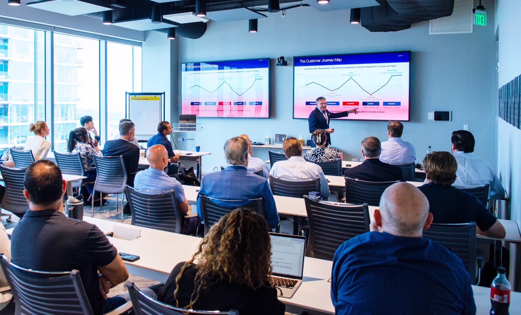 Michael Burcham presenting a customer journey map to a seated room of Project Healthcare founders.